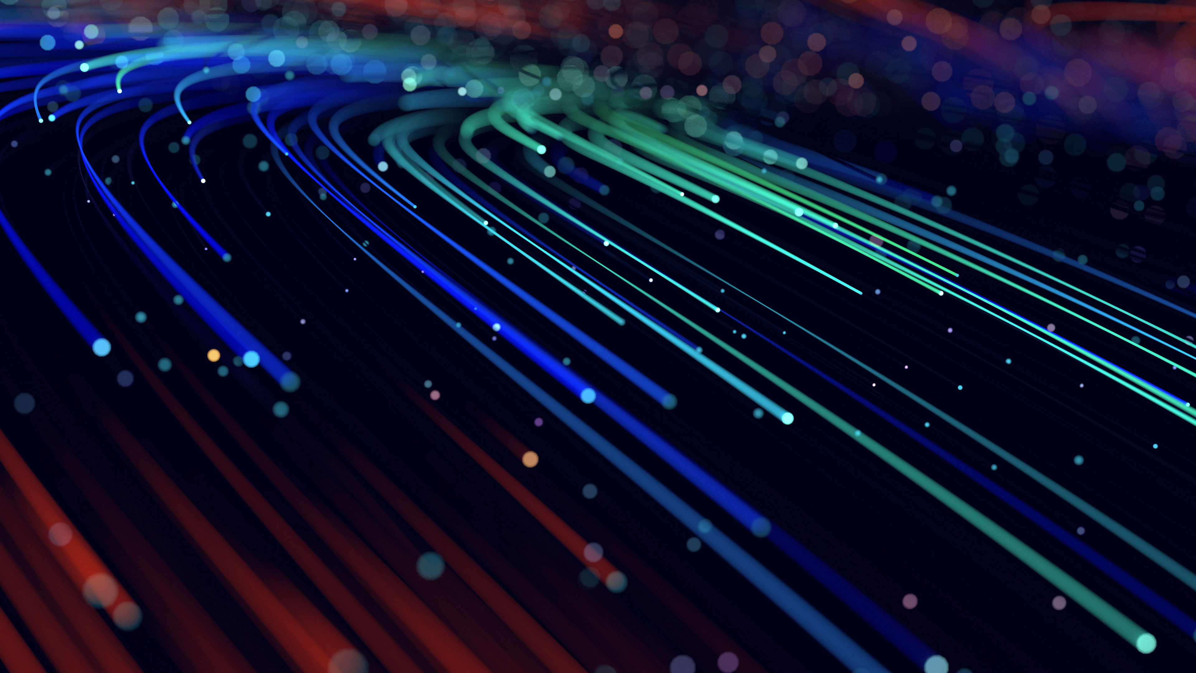 Abstrakte Darstellung von Licht- oder Datenströmen in Blau-, Grün- und Rottönen auf dunklem Hintergrund symbolisch für NetVent7 und das Angebot für Hochleistungs-Netzwerkinfrastruktur für Events